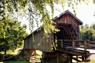 Historical landmark Auchumpkee Creek Covered Bridge in Culloden (Thomaston) Georgia Upson County USA. Lens flare created from bright morning sunlight.