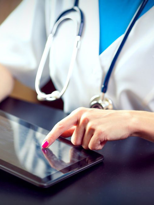 photo of a woman doctor's hands tapping on a tablet