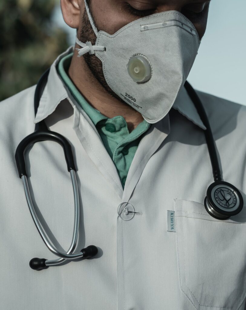 A male physician wearing a face mask and a stethoscope