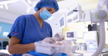 CRNA nurse anesthetist preparing or organizing equipment in a surgical room