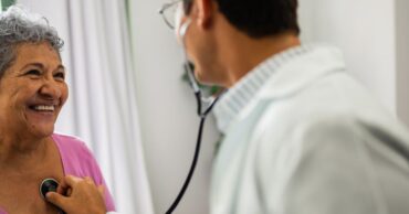 Doctor listening senior patient woman's heartbeat